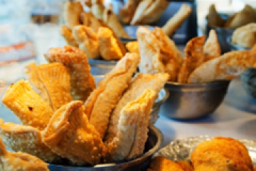 Assorted golden-brown pastries displayed in bowls on a table.