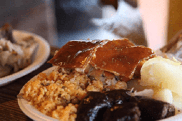 Plate with rice, crispy meat, sausages, and potatoes.